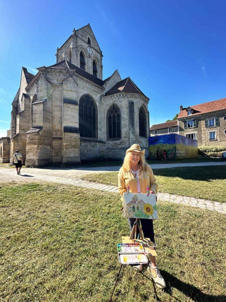 Cindy Briggs painting en plein air in front of the church at Auvers-sur-Oise, France