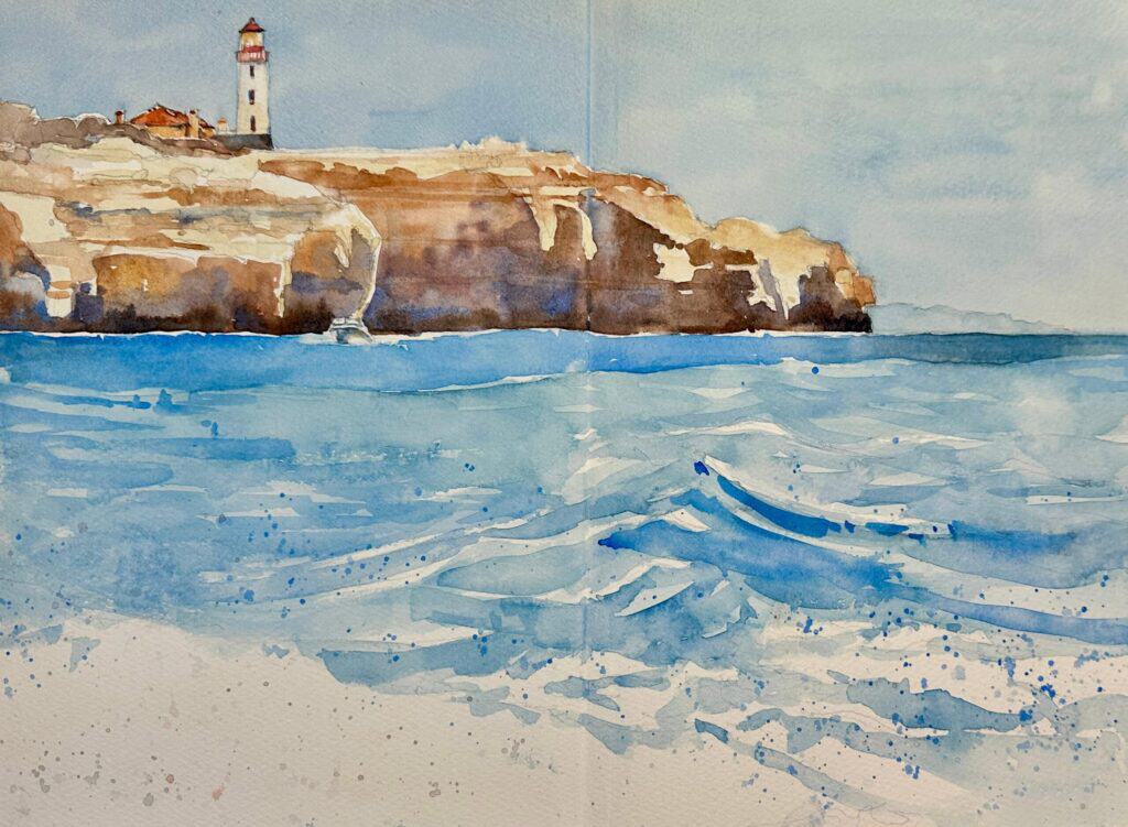 Watercolor painting of a clifftop lighthouse above a blue sea with breaking waves and a pale sand beach