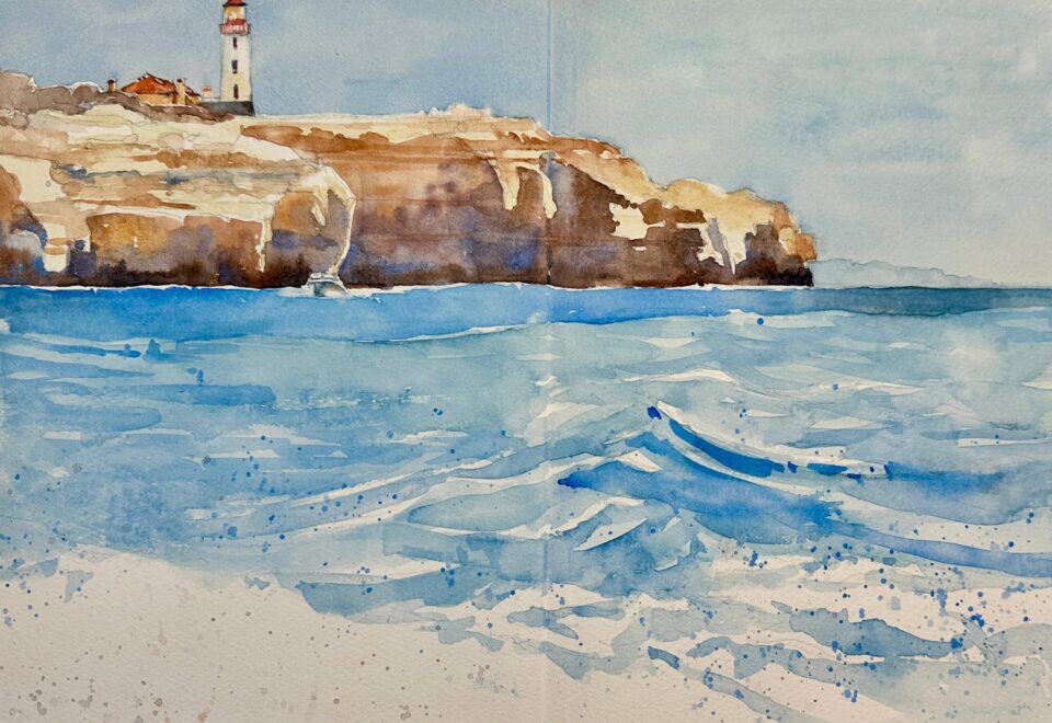 Watercolor painting of a clifftop lighthouse above a blue sea with breaking waves and a pale sand beach