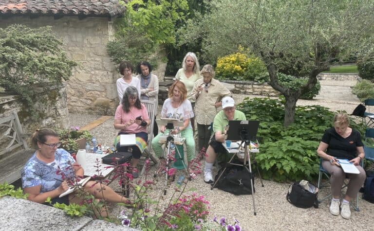 Group of women gathered outdoors for a photography workshop in a garden setting.
